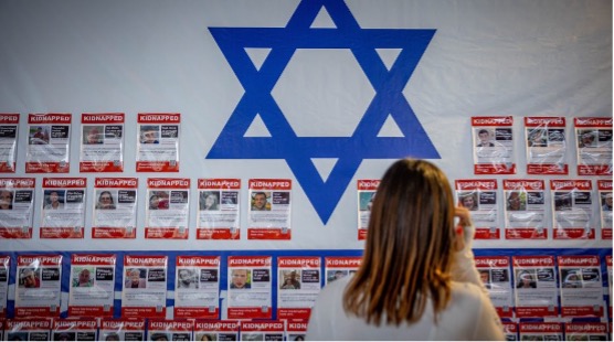人民經過貼滿以色列人質照片的牆，以色列剩餘的人質當何去何從？（照片來源：Yonatan Sindel/Flash90）